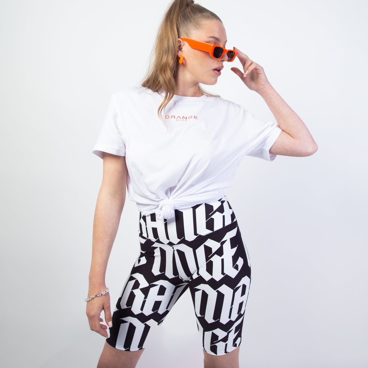 Adoptez le modèle "FULL GOTH MARS LEGGING" (existe en orange/gris ou blanc/noir), un legging court style "cycliste" ultra tendance, incroyable avec des chaussures à plateforme, un petit top d'été, un t-shirt oversize.. Taille haute et ajustée, poche intégrée, se porte près du corps, conception design "gothique" sur toute la surface du legging. Le mannequin porte une taille "S". Crédits Photographie ©Astrid Manoukian / ORANGE MARS OFFICIAL - SHOP ONLINE